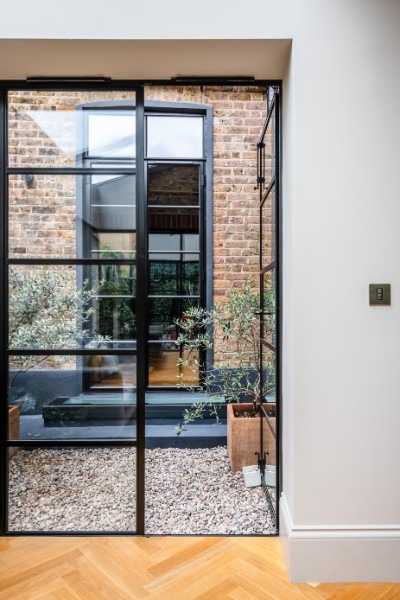 Rear basement extension to a London terrace by UHM Basements, brickwork and glazing